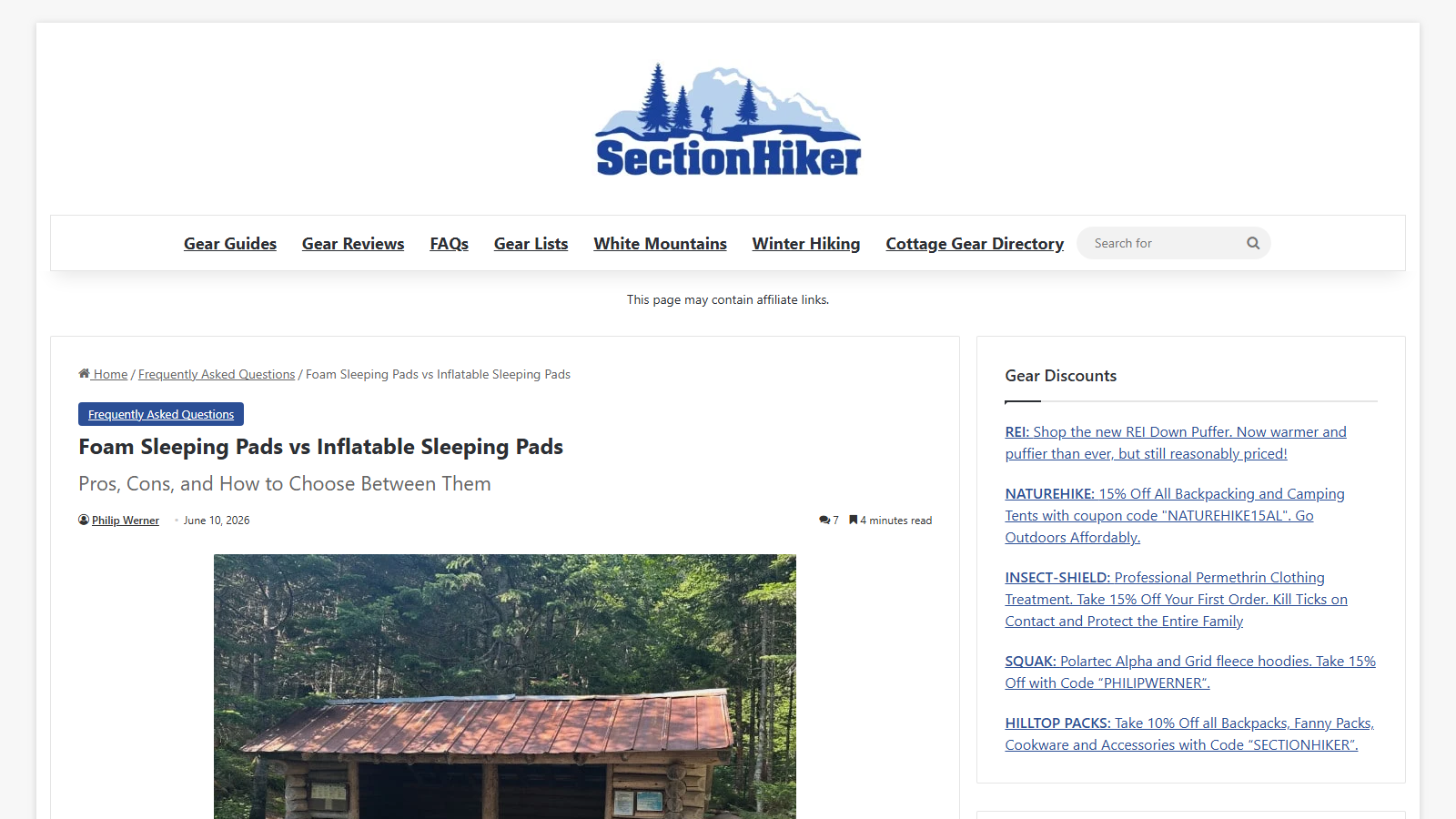 SectionHiker article page headed 'Foam Sleeping Pads vs Inflatable Sleeping Pads' with the subtitle 'Pros, Cons, and How to Choose Between Them', Philip Werner's byline dated June 10, 2026, and a photo of a log trail shelter with a red metal roof in a forest; a Gear Discounts sidebar sits on the right.