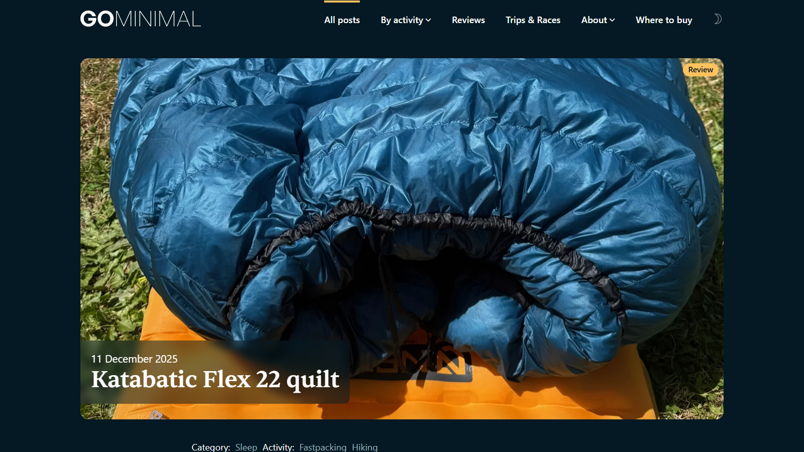 Close-up of a blue down quilt with its drawcord footbox opening, lying on an orange sleeping pad on grass, with the headline 'Katabatic Flex 22 quilt' and the date 11 December 2025 overlaid at lower left
